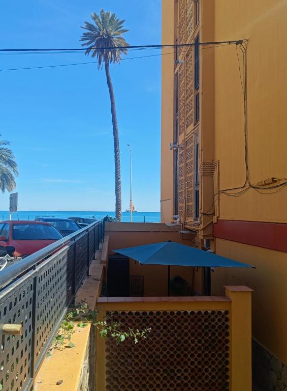 a table on the balcony of a building with a palm tree at BEACH&GARDEN in Málaga