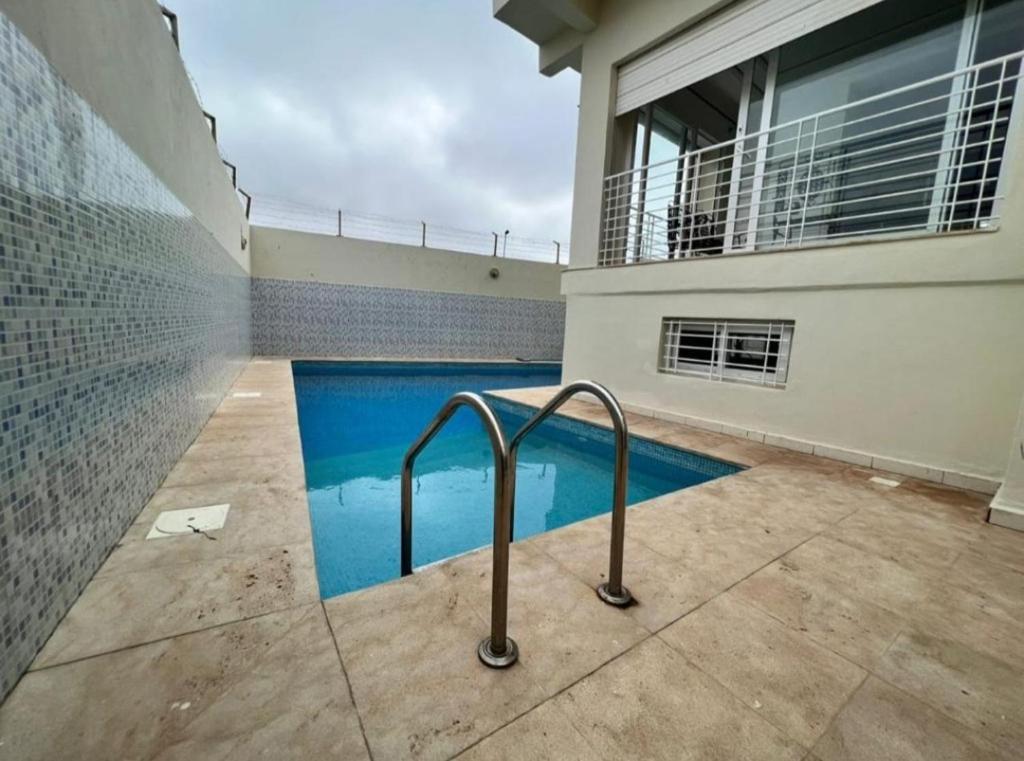 a swimming pool in front of a house at Villa avec piscine privée in El Jadida