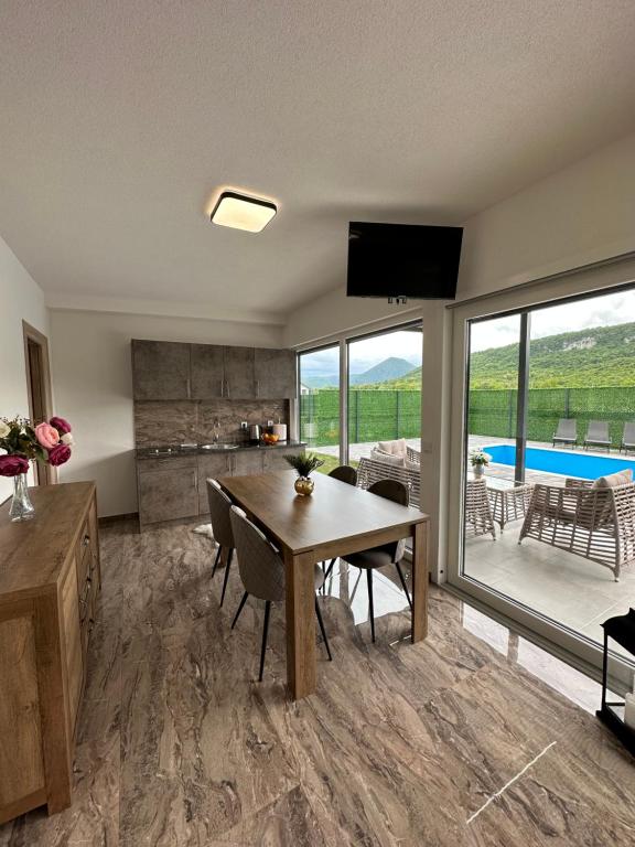 a kitchen and dining room with a table and a television at Terra Solis Bihać Villa 1 in Bihać