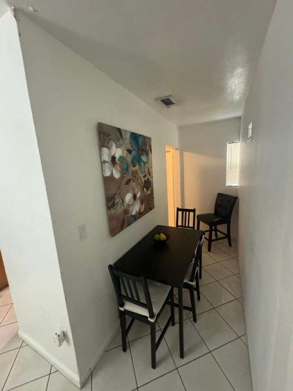 Un comedor con una mesa y sillas negras. en Ludge by Miami Airport, en Miami