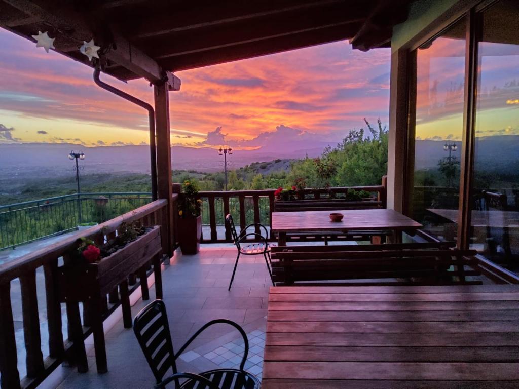 a deck with a table and chairs and a sunset at Hani i Leks Agroturizem in Lezhë
