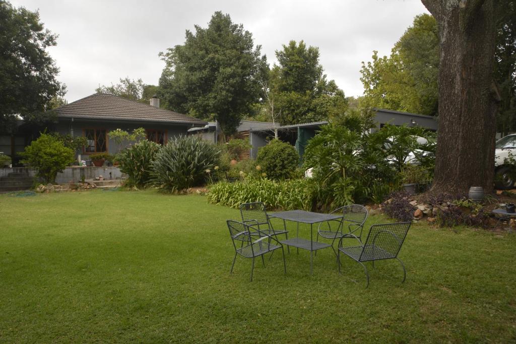 a table and chairs in the grass in a yard at Pender House Cottage Melrose in Johannesburg