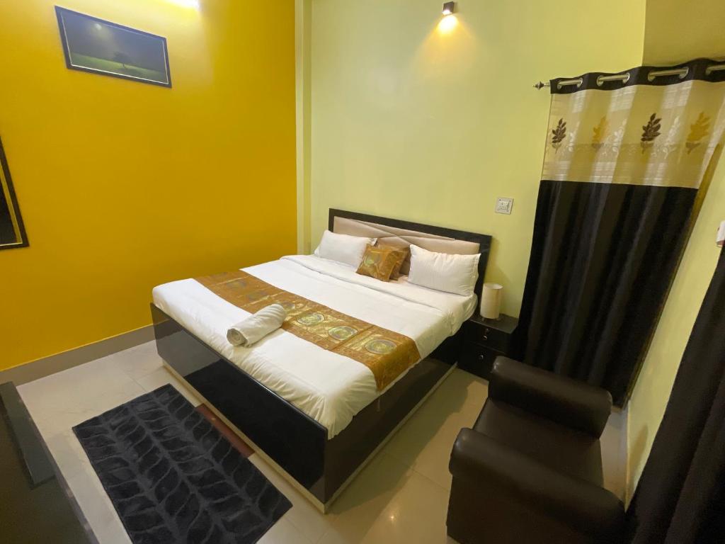 een kleine slaapkamer met een bed en een stoel bij SHANKR VILAAS benaras Luxury stay in Varanasi