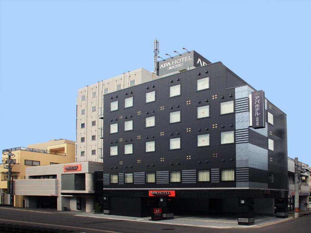 un grand bâtiment noir sur le côté d'une rue dans l'établissement APA Hotel Takamatsu Kawaramachi, à Takamatsu