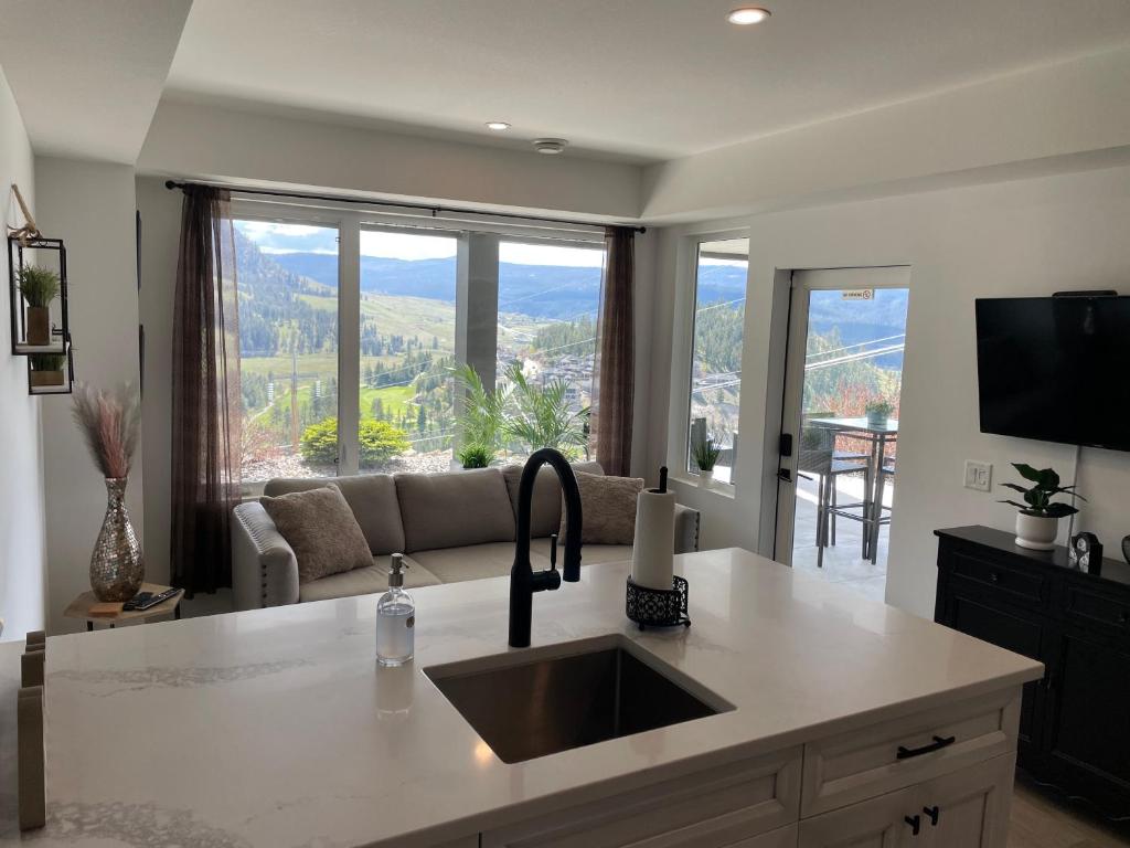 a kitchen with a sink and a living room at Black Mountain Amazing Home on Golf Course in Kelowna