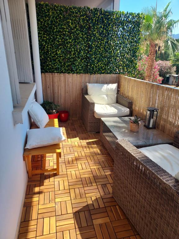 d'une terrasse avec un canapé et des chaises sur un balcon. dans l'établissement Grand T2 ensoleillé - Proche Gare, à Hyères