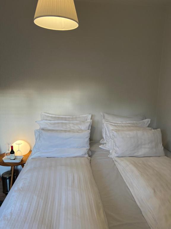 a bedroom with two beds with white pillows at Unik BnB midt i byen - mad event og bilopladning in Herning