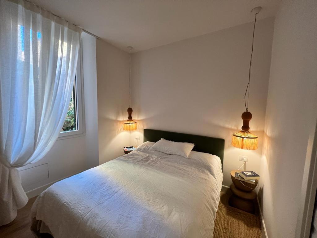 a bedroom with a white bed and two lights at Camogli - "Il Nido" - Liguria Holidays in Camogli