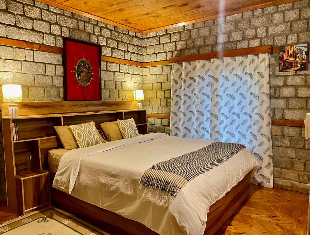 um quarto com uma cama numa parede de tijolos em The OakHurst em Manali