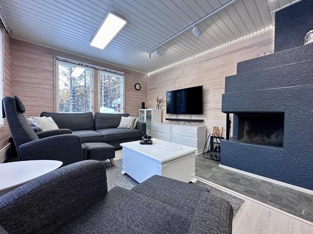 - un salon avec des canapés et une cheminée dans l'établissement Villa Kiviaapa in Ruka Kuusamo, à Ruka
