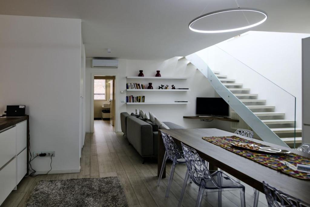 a kitchen and dining room with a table and a staircase at SWEETHOME MUSEO - con Garage in Bolzano