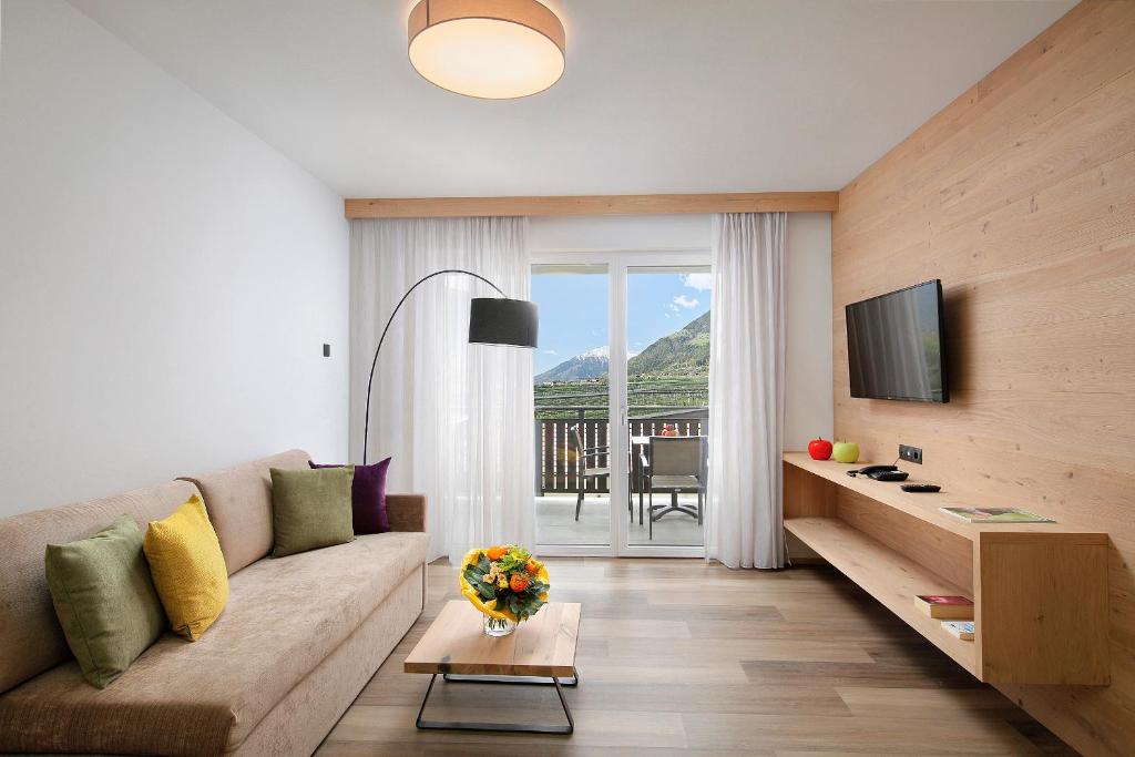 uma sala de estar com um sofá e uma televisão em Appartement-Hotel Anthea em Tirolo