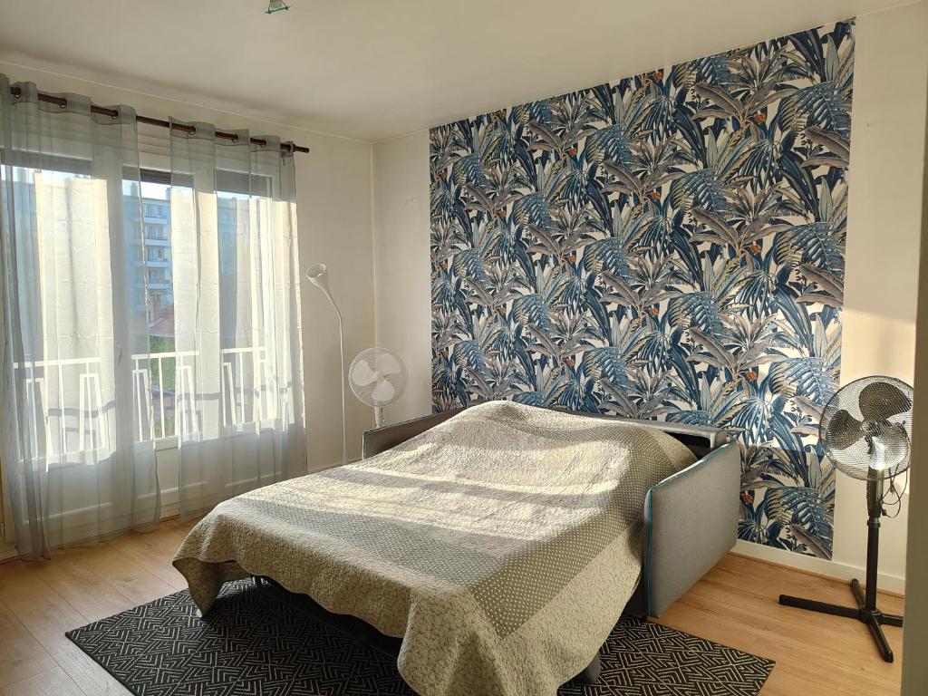 a bedroom with a bed and a wall with a floral wallpaper at Amaryllis in La Tronche