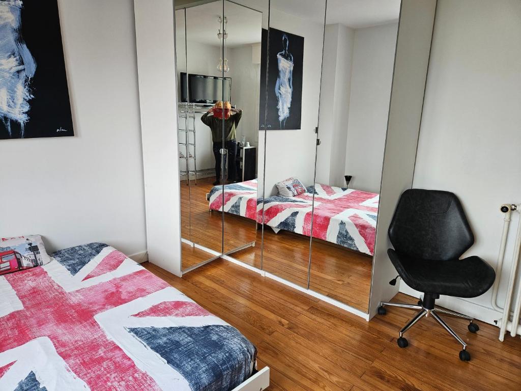 une chambre avec deux lits et un miroir dans l'établissement Une chambre chez Christina 250m de la plage, à Royan