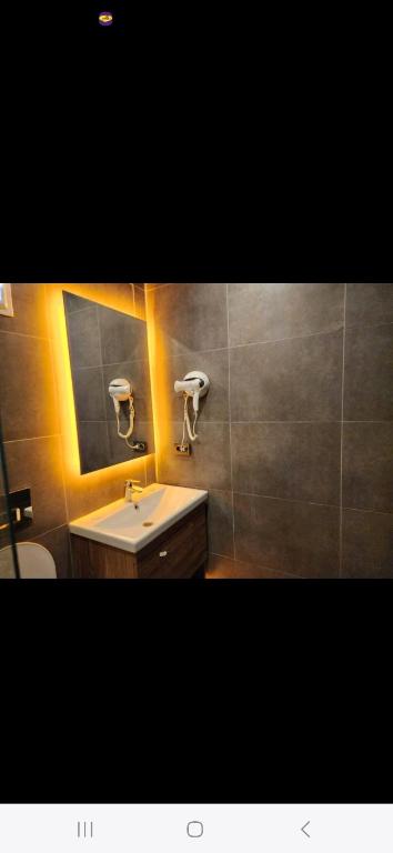 a bathroom with a sink and a mirror and a toilet at Başar hotel in Erdemli
