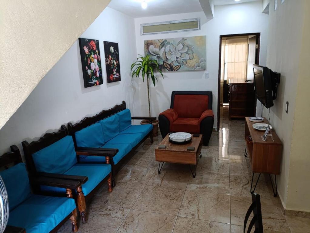een woonkamer met blauwe banken en een tafel bij La casa de Luna in Puerto Vallarta