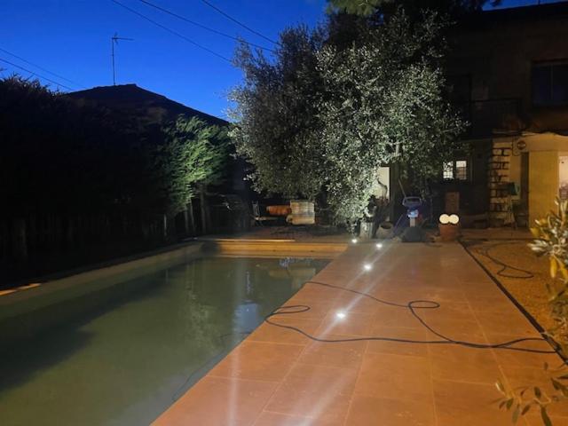 une piscine dans une cour la nuit dans l'établissement Maison idéale pour famille proche de toutes commodités, à Carpentras