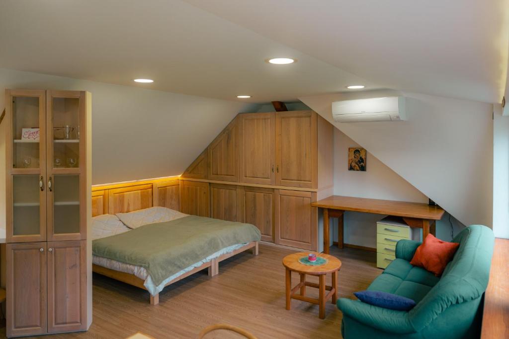 um quarto no sótão com uma cama e um sofá em Country Retreat, Near Ljubljana City, Apartma na vasi, blizu mesta Ljubljana em Medvode