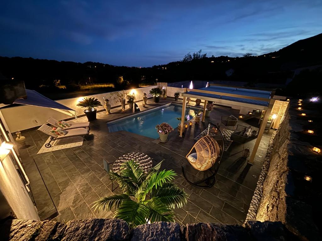 - une vue sur la piscine la nuit dans l'établissement Studio, piscine, 10 min des plages, Ajaccio, corse du sud,, à Appietto