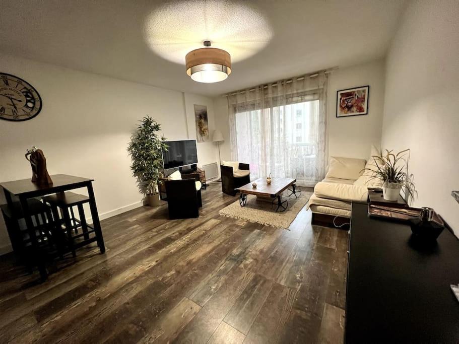 un salon avec un canapé et une table dans l'établissement Appartement très bien situé avec parking privé, à Montpellier