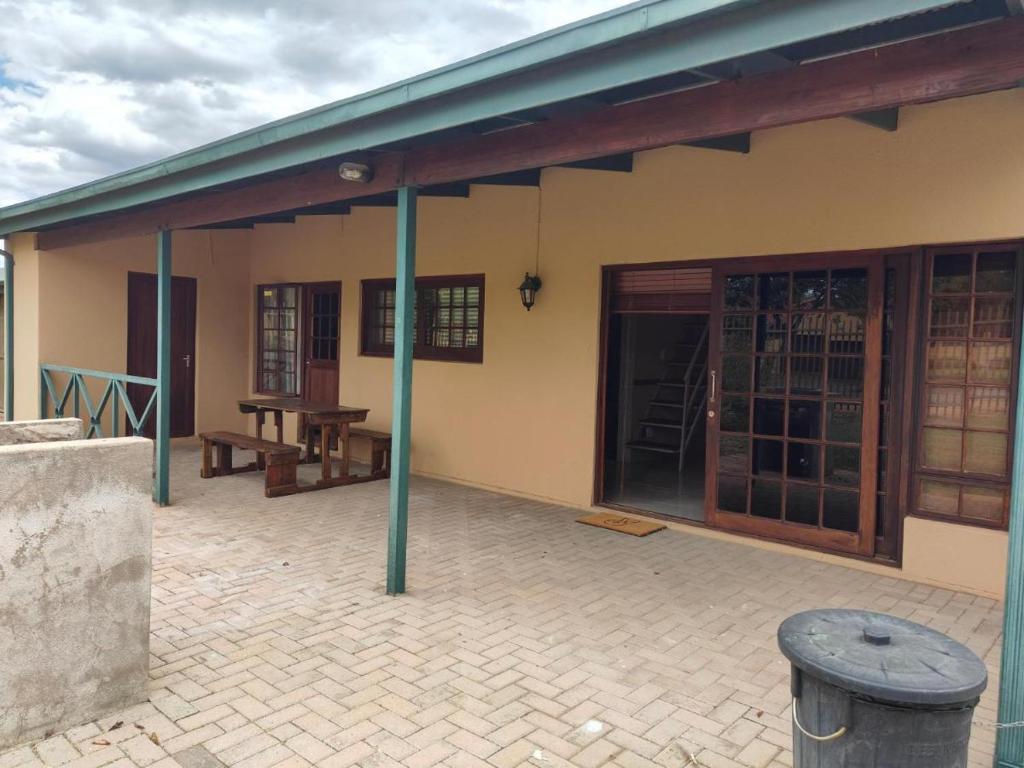 a building with a porch with a bench and a table at 20 Pendleberry Holiday Resort in Bela-Bela