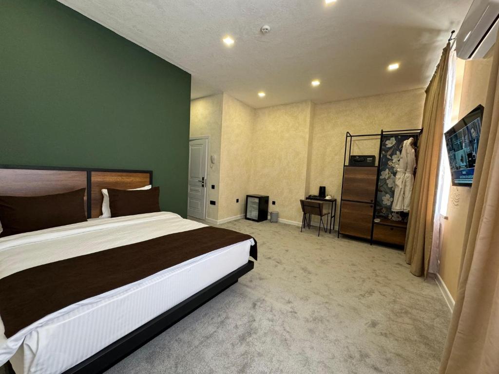 a bedroom with a large bed and a desk at Liberta Hotel Baku in Baku