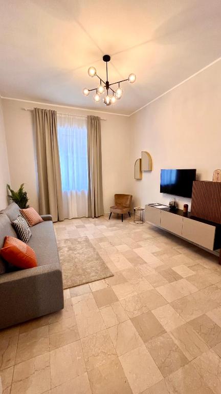 uma sala de estar com um sofá e uma televisão em Appartamento moderno Freidour, metro Rivoli em Turim