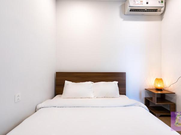 een slaapkamer met een wit bed en een televisie bij River Panorama 2 Bedroom River View in Ho Chi Minh-stad