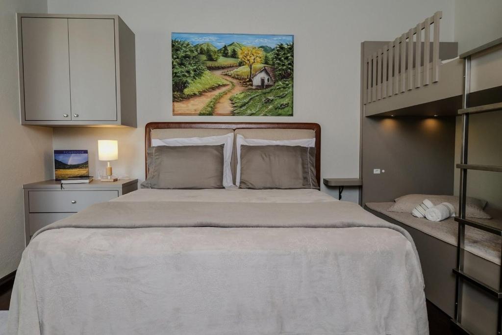 a bedroom with a large bed and a staircase at Hospedagem Tri-Best in Pomerode