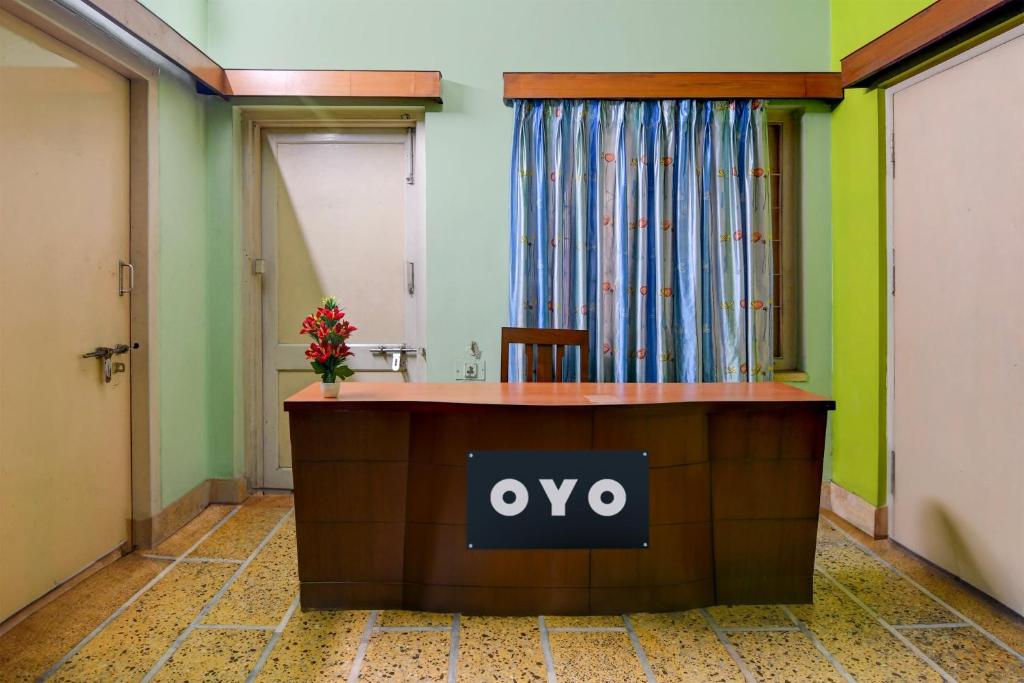 um escritório com uma placa de oro na recepção em OYO Ramya Guest House em Calcutá