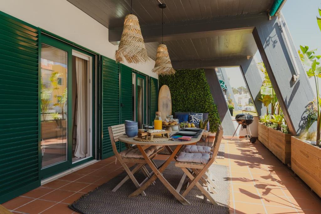 eine Terrasse mit einem Tisch und Stühlen auf dem Balkon in der Unterkunft Surf GuestHouse - 7min walk to the beach in Pataias