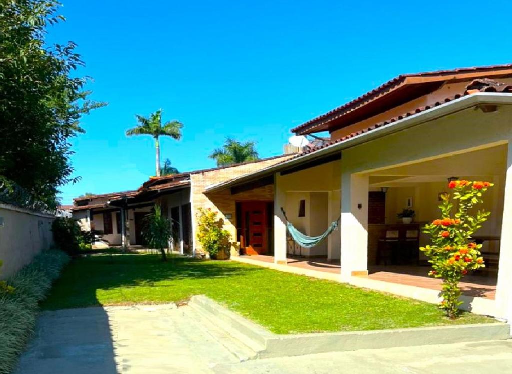 een huis met een groen gazon ervoor bij Casa a uma quadra da praia in Maresias