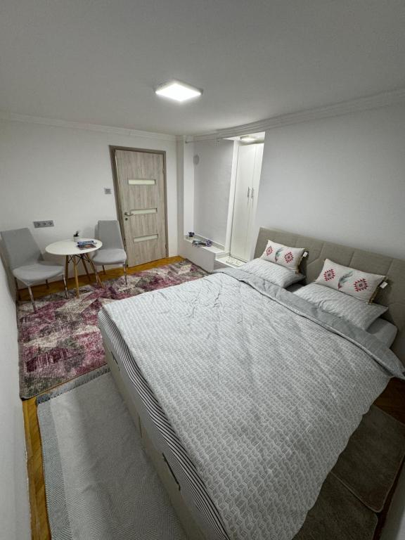 a bedroom with a large bed and a table at Your Room in Sarajevo
