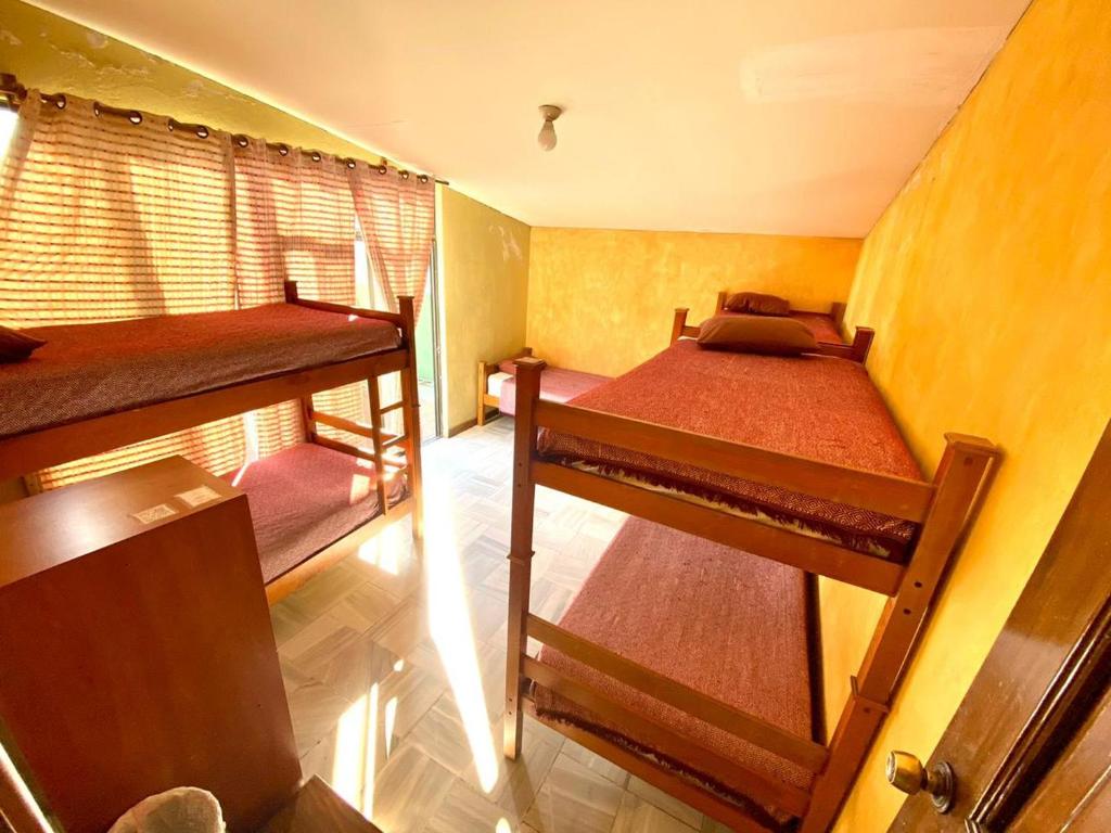 a small room with two bunk beds and a window at HOTEL IXBALANQUE in La Aurora
