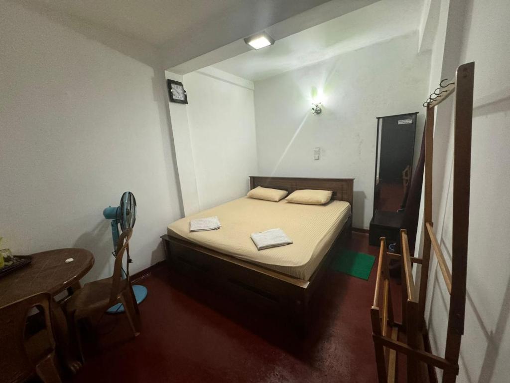 - une petite chambre avec un lit et une table dans l'établissement Madura Rest, à Kandy