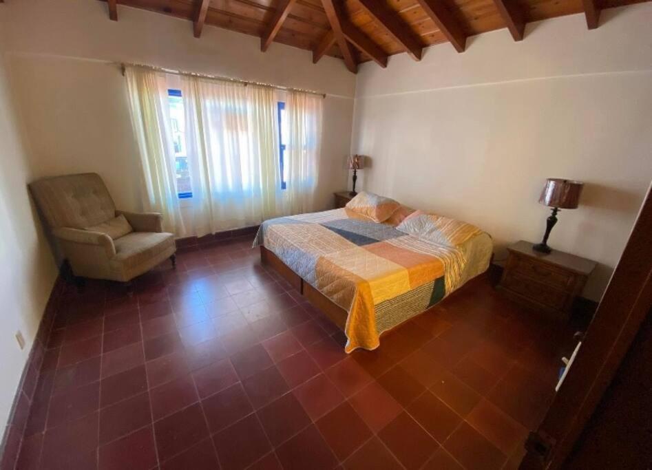 um quarto com uma cama e uma cadeira em casa y bungalows frente al mar em Rosarito