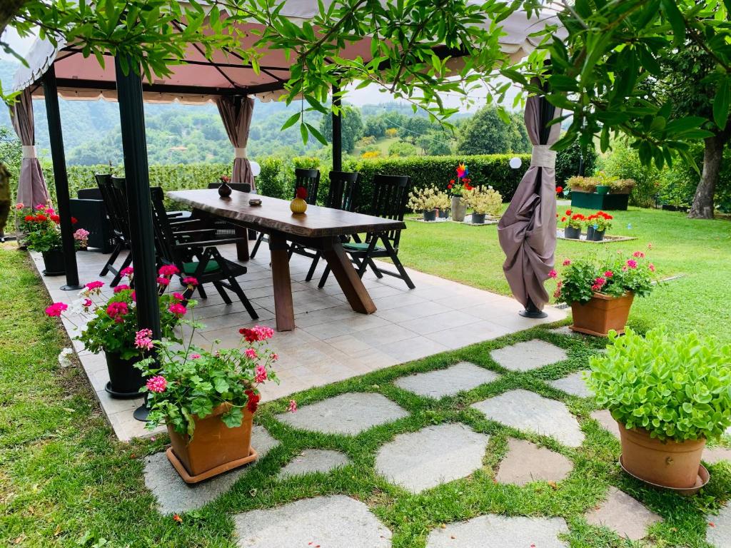 stół i krzesła pod altaną z kwiatami w obiekcie B&B Codivilla w mieście Sasso Marconi