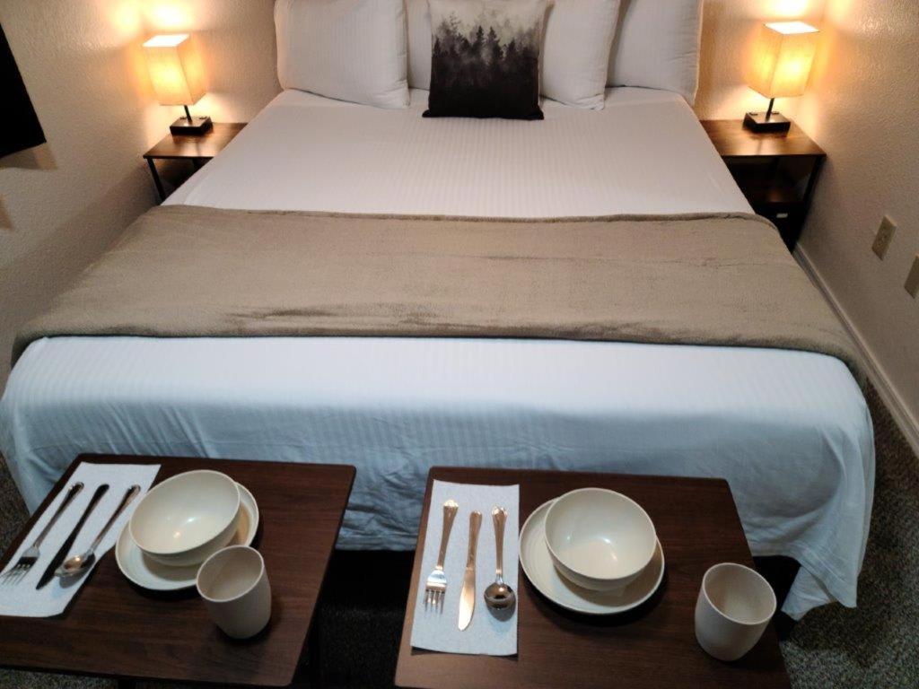 ein Hotelzimmer mit einem Bett mit zwei Holztischen in der Unterkunft 069A Private Studio with kitchen near South Rim Sleeps 4 in Valle