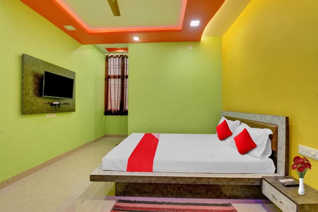 a bedroom with a bed with red and green walls at Flagship The Heart Residency in Rāmgarh