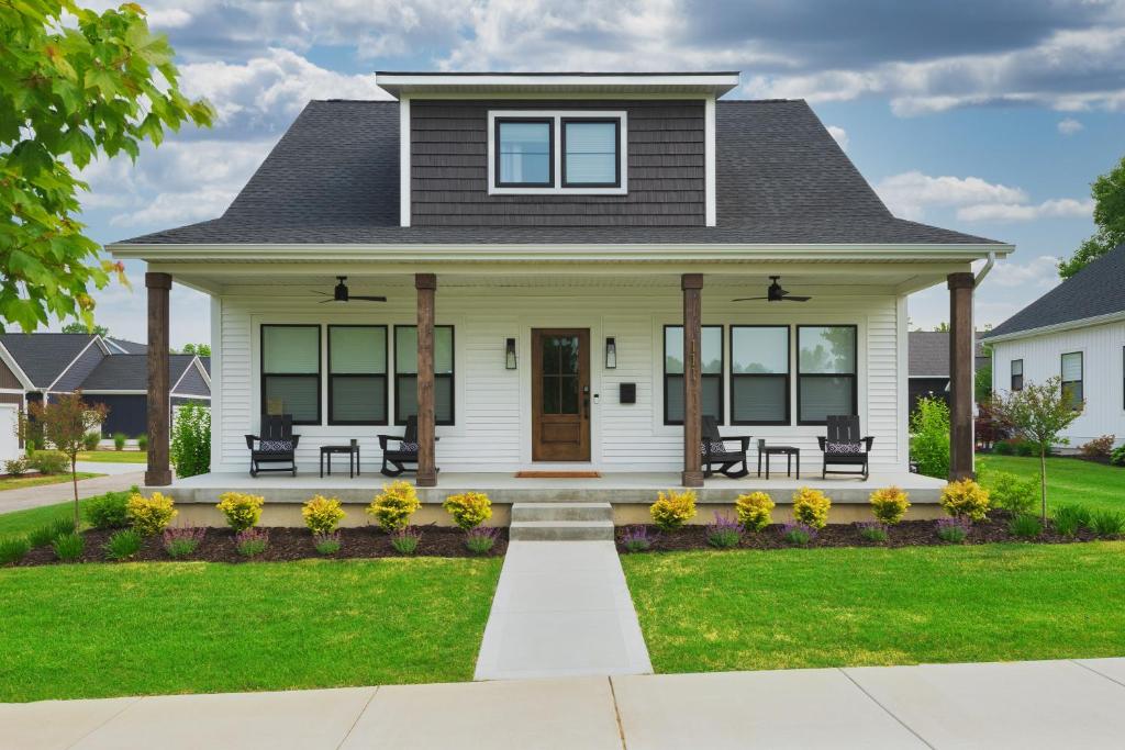 a house with a front porch with benches at Bonjour Soha- pool- close to beach in South Haven