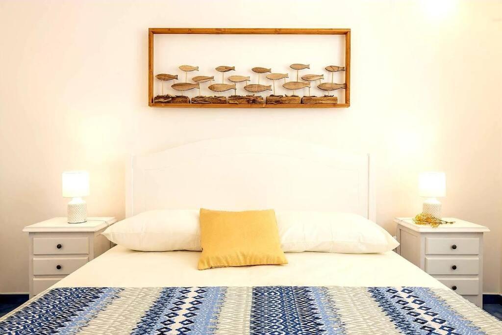 a bedroom with a white bed with two night stands at Belvedere Apartments A in Marina di Mancaversa