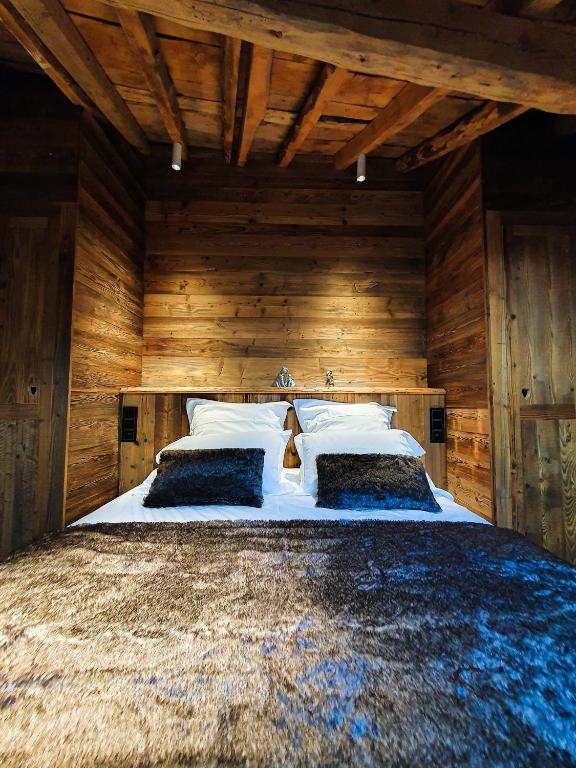 - une chambre avec un grand lit et des murs en bois dans l'établissement Les Fermes de Cal Panche : Le Cabanat, aux Angles