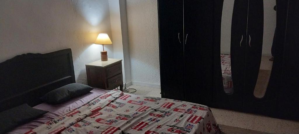sypialnia z łóżkiem i lampką na stoliku nocnym w obiekcie L'escale w mieście Tunis