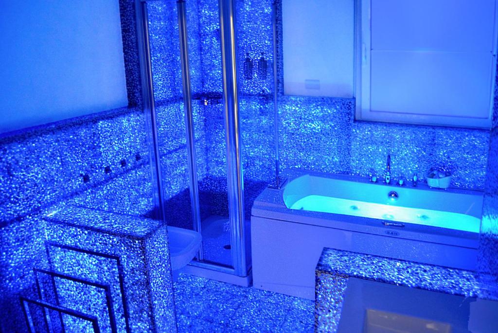 ein blaues Badezimmer mit einer Badewanne, einem WC und einem Waschbecken in der Unterkunft Spa Apartment in centro in Genua