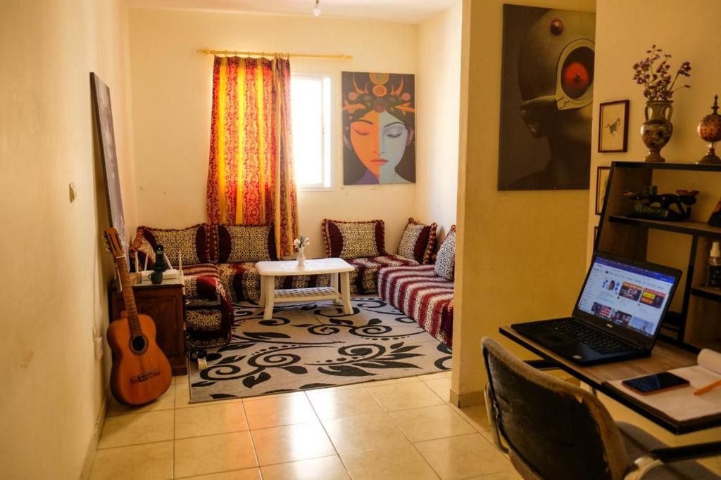 a living room with a couch and a table with a laptop at Room in Agadir Morocco in Agadir