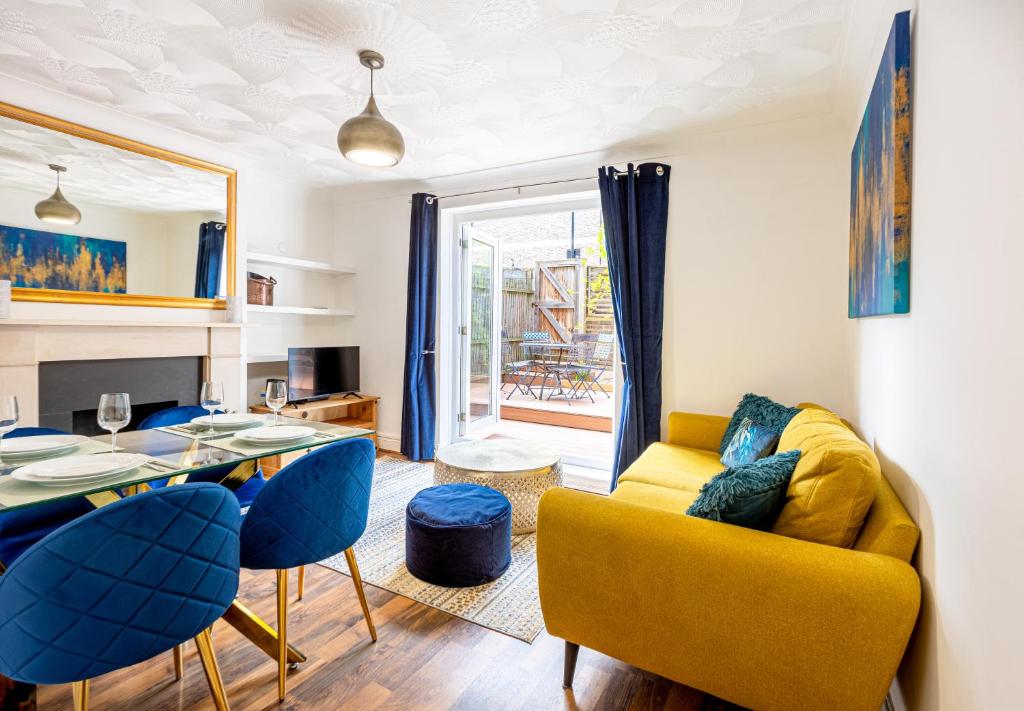een woonkamer met een gele bank en blauwe stoelen bij Renovated 2-Storey 2BR wGarden near Angel St in Londen