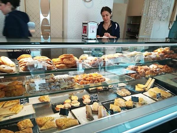 a woman standing behind a display case in a bakery at B&B Francesco in Pisa