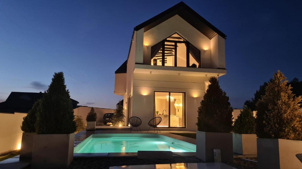 a villa with a swimming pool at night at Villa Blanca in Cedzyna