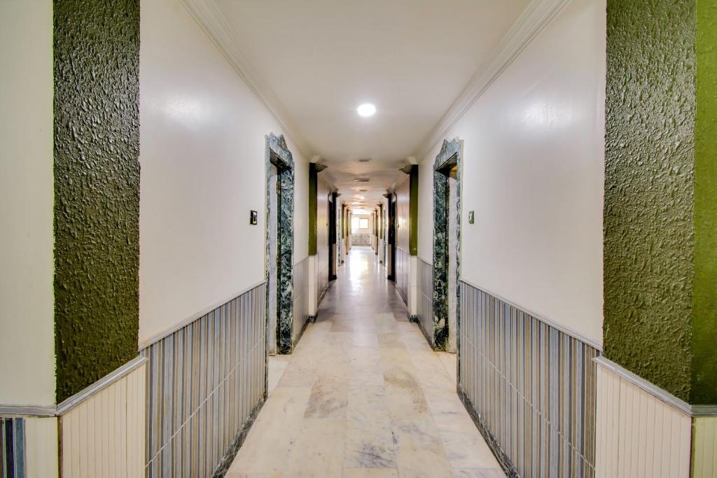 an empty corridor in a building with green walls at SPOT ON Hotel Green Valley in Vijayawāda