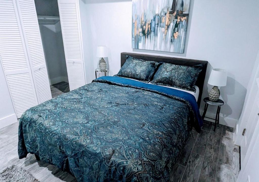 a bedroom with a bed with a blue comforter at Luxurious 3 Bedroom Apt with a beautiful balcony in Washington
